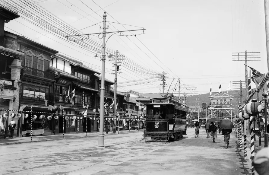 明治45年6月、四条小橋―四条西洞院間に四条線が開業。通り沿いに竣工を祝う提灯が飾られ、祝賀のためのアーチが建てられているのが見える（京都府立京都学・歴彩館寄託 石井行昌撮影写真資料）