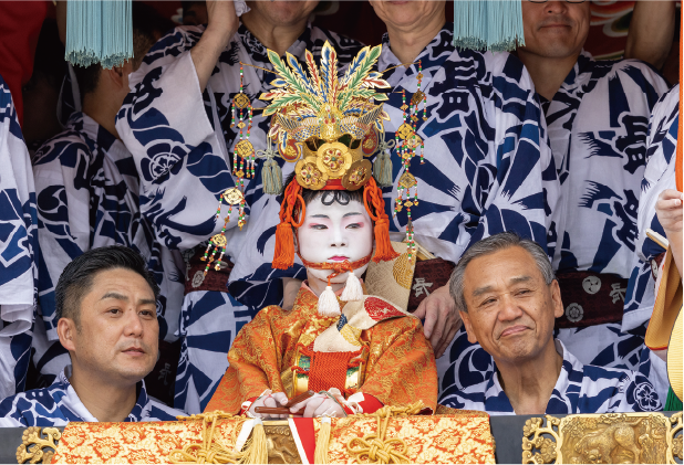 7月17日の山鉾巡行。稚児を務める雅基さんの左が西川氏。右は義父の山田正太郎氏。